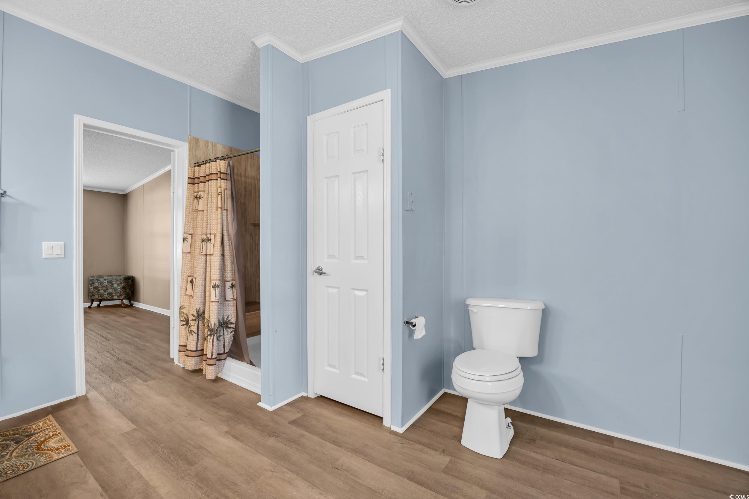 3373 Lake Pond Road Loris, SC 29569 - Photo 9 of 33 Bathroom featuring crown molding, wood finished floors, a stall shower, and a textured ceiling