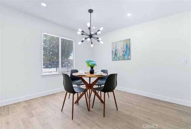 a view of a dining room with furniture a chandelier and wooden floor