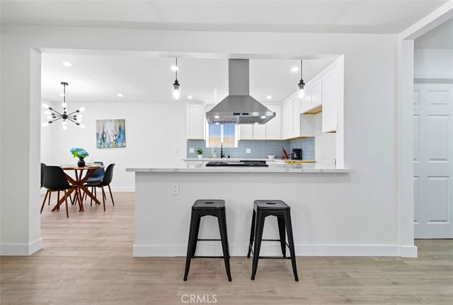 a kitchen with kitchen island a dining table and chairs