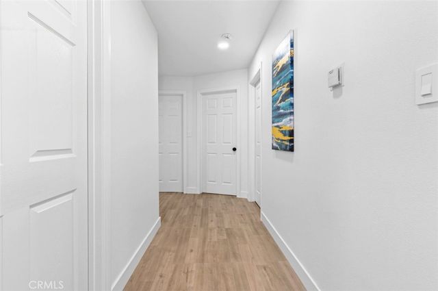 a view of a hallway with wooden floor and entryway