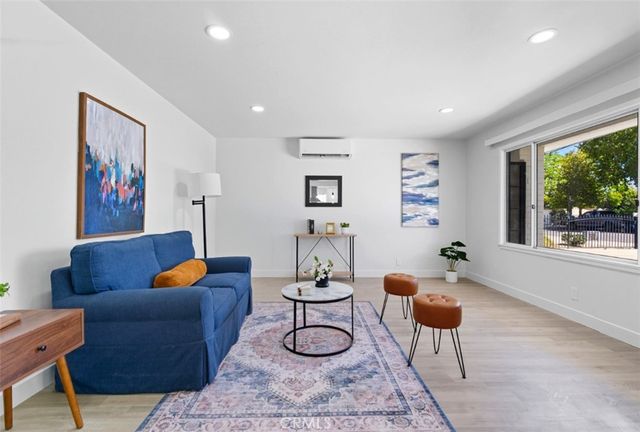 a living room with furniture potted plant and a large window