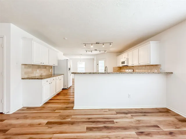a view of kitchen with wooden floor and electronic appliances