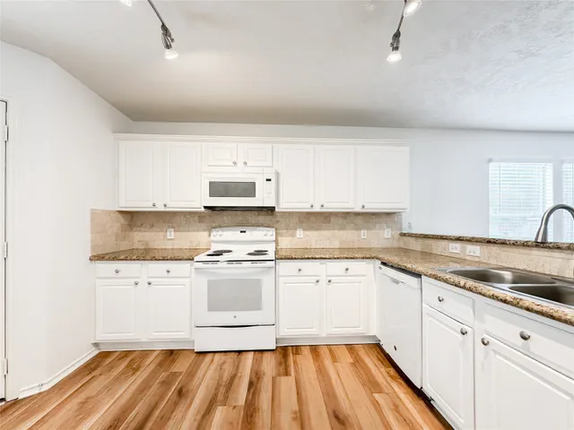 a kitchen with granite countertop a sink and cabinets