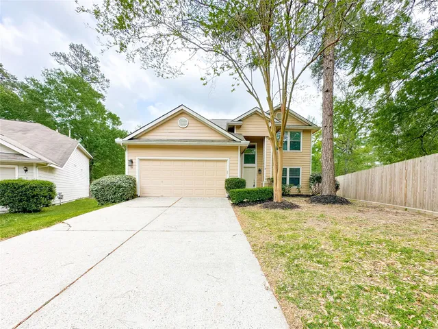a front view of a house with a garden and trees