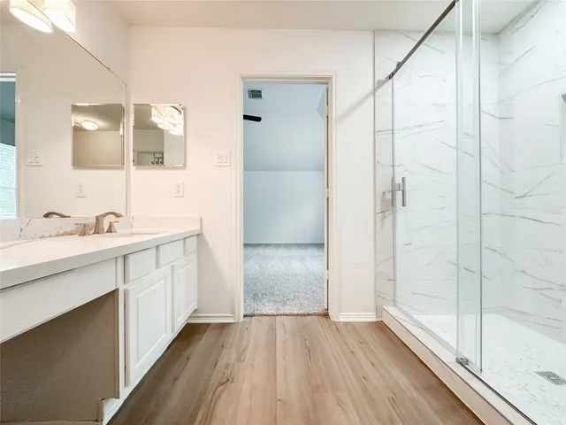a bathroom with a double vanity sink a mirror and a shower