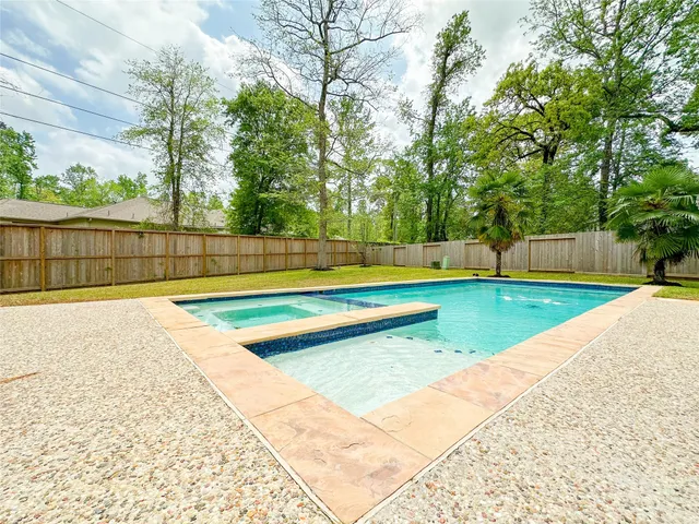 a view of swimming pool with a yard and large trees