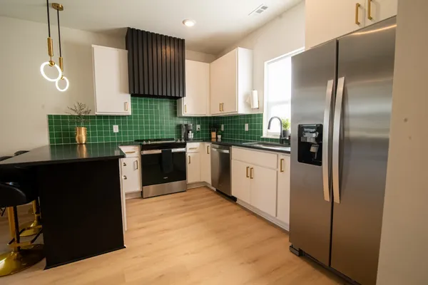 a kitchen with a refrigerator sink and white cabinets