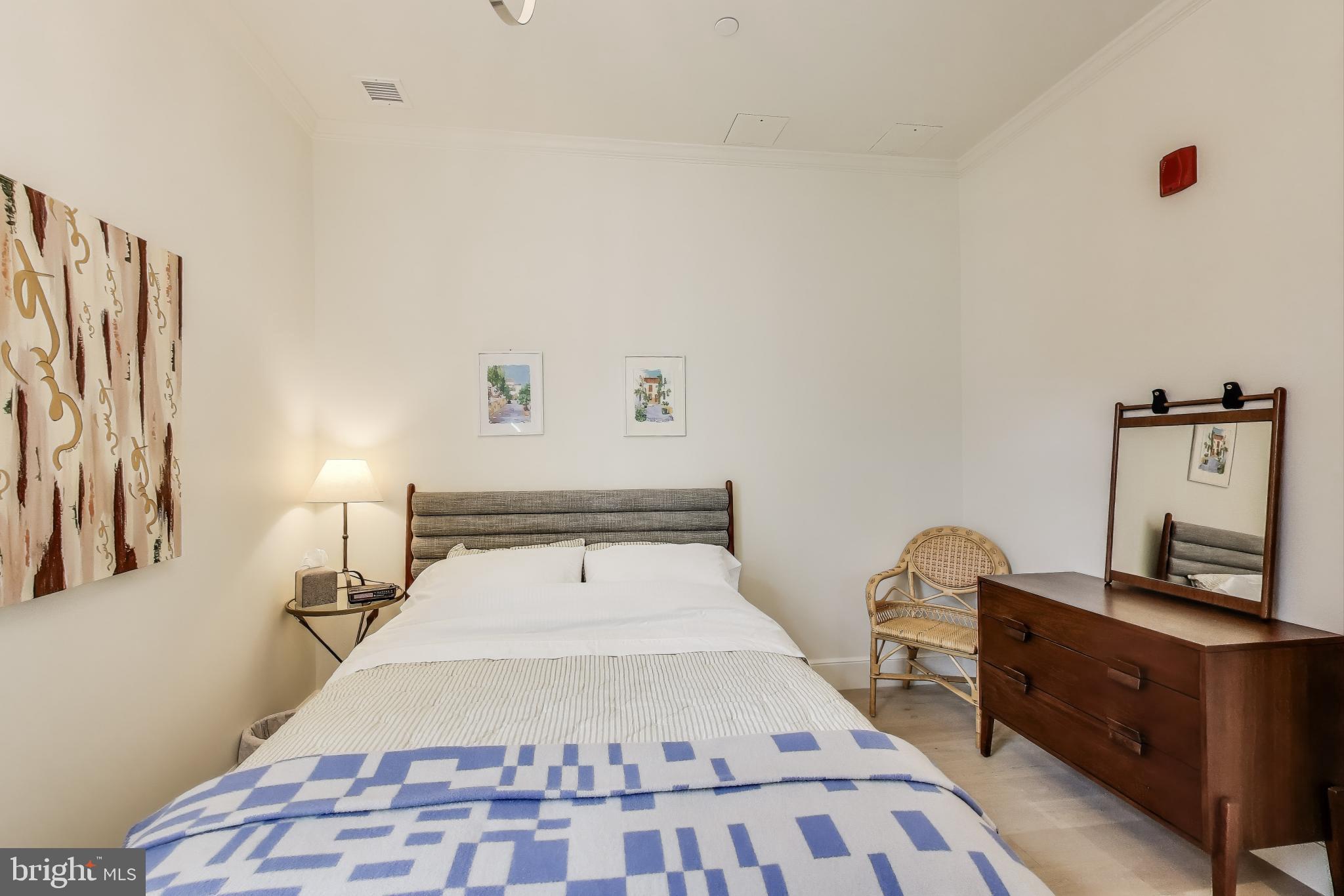 2122 N Street Northwest, Unit 5 Washington, DC 20037 - Photo 20 of 38 a bedroom with a bed and wooden floor
