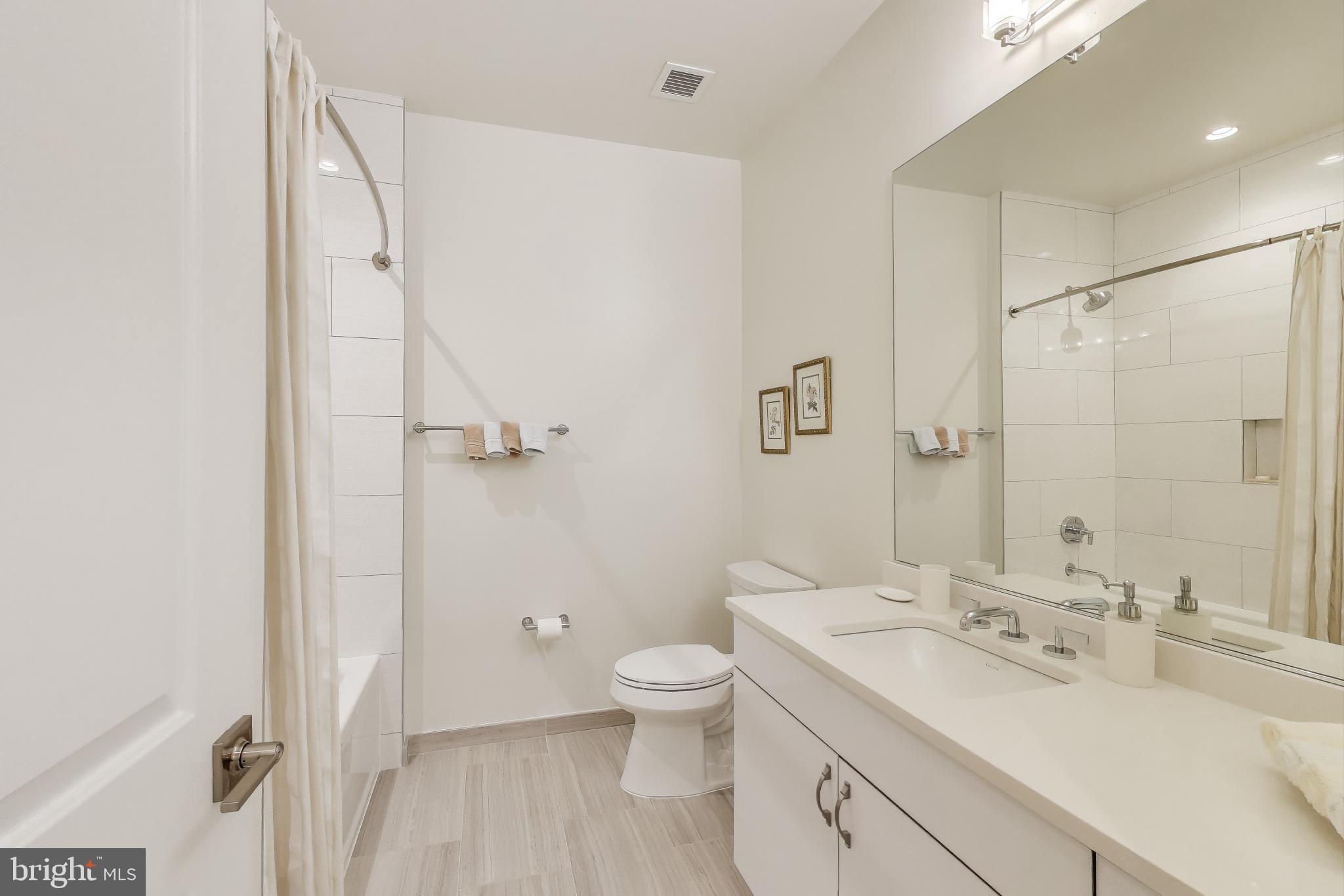 2122 N Street Northwest, Unit 5 Washington, DC 20037 - Photo 21 of 38 a bathroom with a double vanity sink toilet mirror and shower