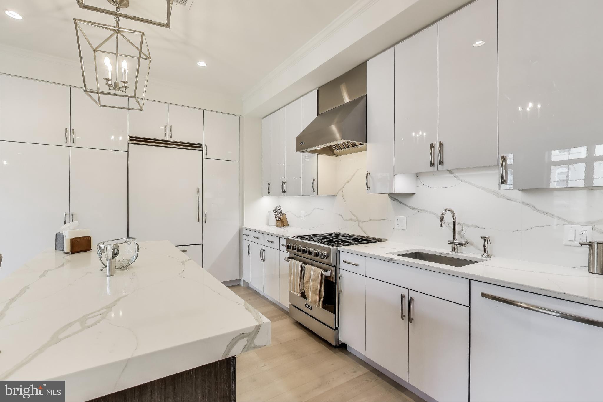 2122 N Street Northwest, Unit 5 Washington, DC 20037 - Photo 8 of 38 a kitchen with white cabinets and appliances
