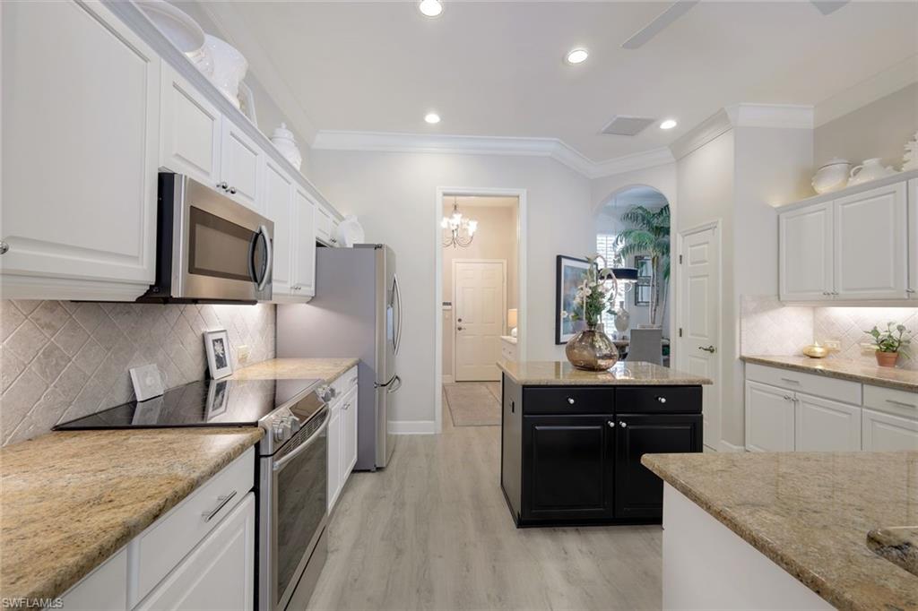 8475 Gleneagle Way Naples, FL 34120 - Photo 18 of 46 a kitchen with stainless steel appliances granite countertop a sink stove and refrigerator