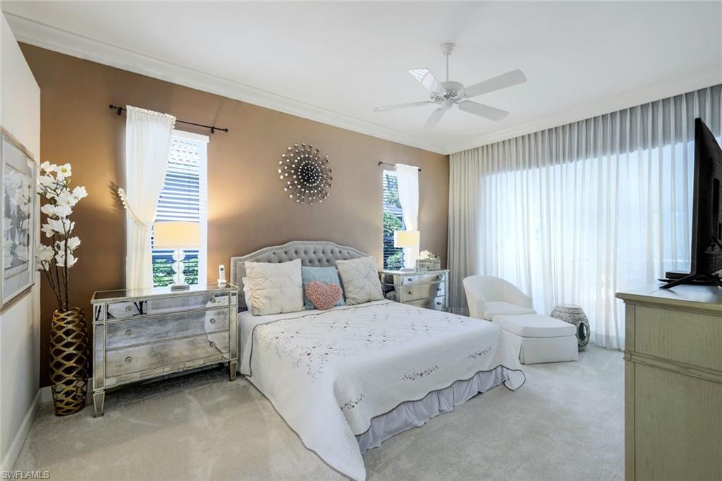 8475 Gleneagle Way Naples, FL 34120 - Photo 21 of 46 a spacious bedroom with a bed a couch and a window