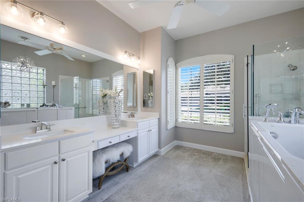 8475 Gleneagle Way Naples, FL 34120 - Photo 24 of 46 a spacious bathroom with a double vanity sink a large mirror and a bathtub