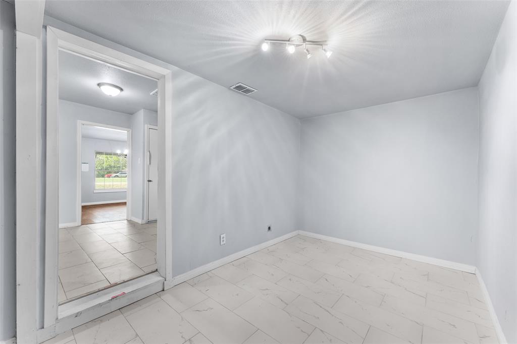 612 East 8th Street Kemp, TX 75143 - Photo 22 of 25 Bright interior room with track lighting, light-toned walls, and large format tile flooring
