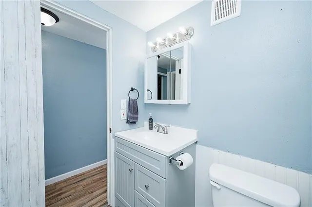 a bathroom with a toilet sink and mirror
