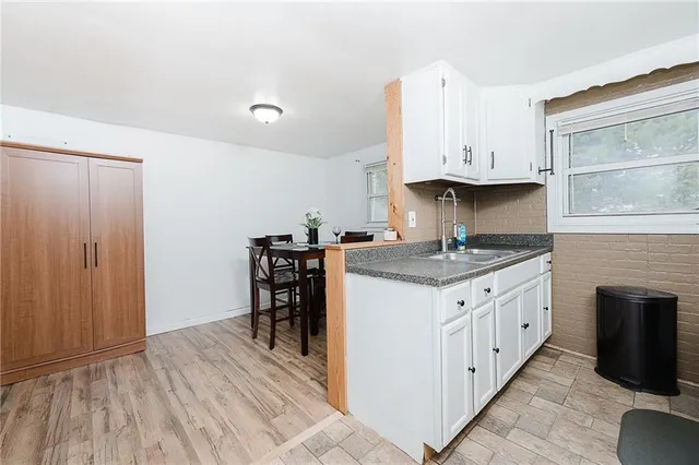 a kitchen with granite countertop a sink stove and cabinets