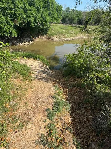a view of a lake with beach and green space