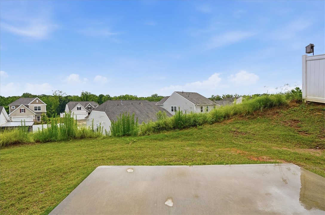 365 Sliding Rock Drive Pendleton, SC 29670 - Photo 31 of 46 A spacious backyard with a concrete patio offers views of neighboring residences and a clear sky.