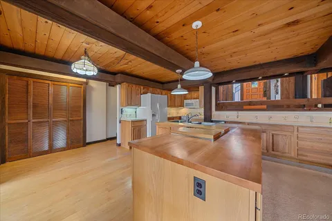 a view of a kitchen with stainless steel appliances granite countertop a sink a stove and a refrigerator