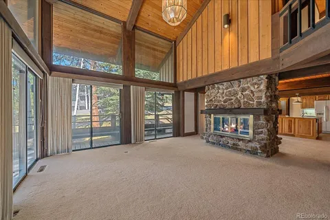 a view of an empty room with a fireplace and a window