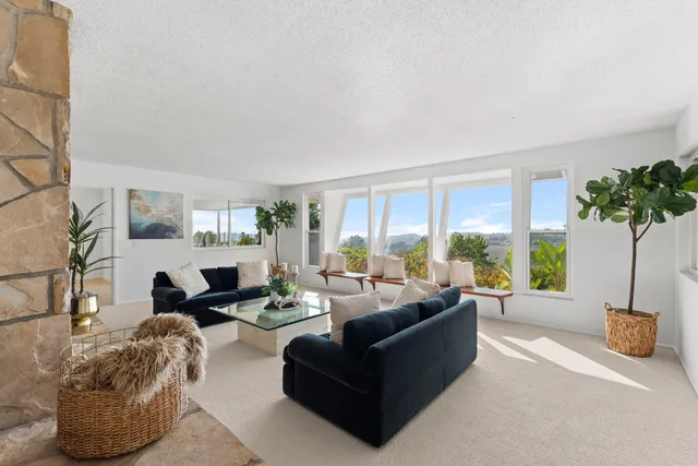 a living room with furniture and a floor to ceiling window