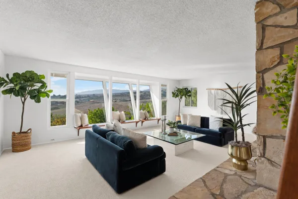 a living room with furniture potted plant floor and a large window