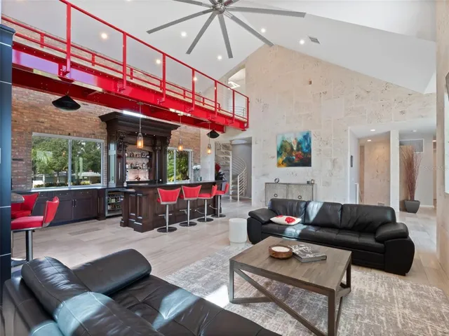 a living room with furniture a ceiling fan and a wooden floor