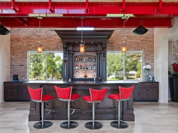 a spacious bedroom with a bed a dresser and a chandelier