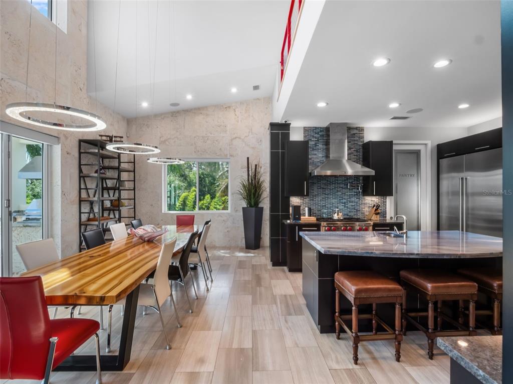 1511 South Riverside Drive New Smyrna Beach, FL 32168 - Photo 27 of 81 a kitchen with stainless steel appliances kitchen island granite countertop a sink table and chairs