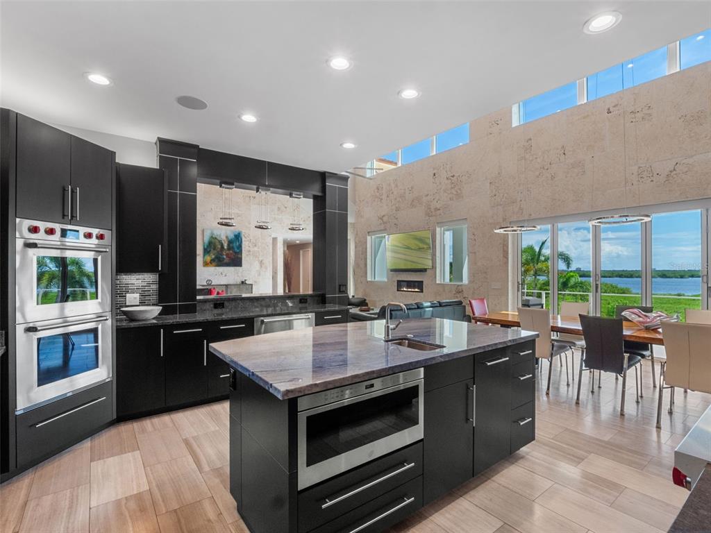 1511 South Riverside Drive New Smyrna Beach, FL 32168 - Photo 32 of 81 a kitchen with center island counter top space a sink stainless steel appliances and windows