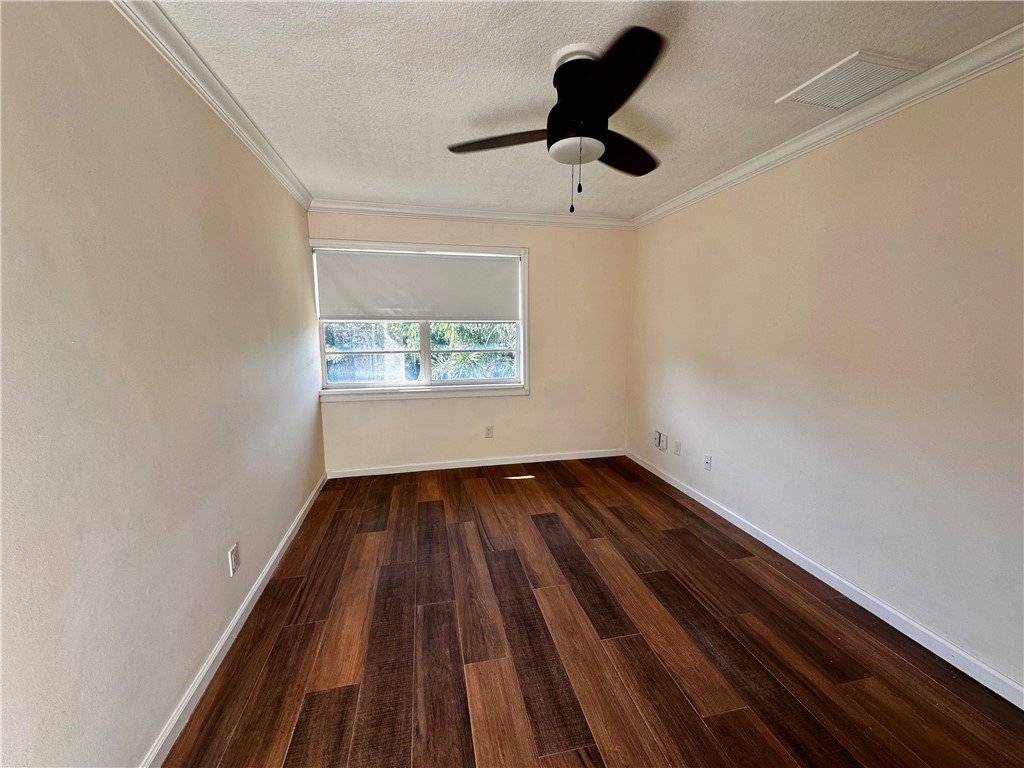 1815 Robalo Drive, Unit C201 Vero Beach, FL 32960 - Photo 15 of 31 a view of an empty room with wooden floor and a window