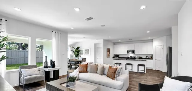 a living room with furniture and kitchen view