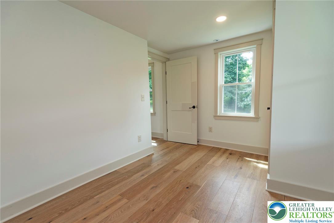 72 Allegheny Road Mount Bethel, PA 18343 - Photo 22 of 72 Luminous hardwood floors flow through this well-appointed room, offering serene views of verdant trees from the windows.