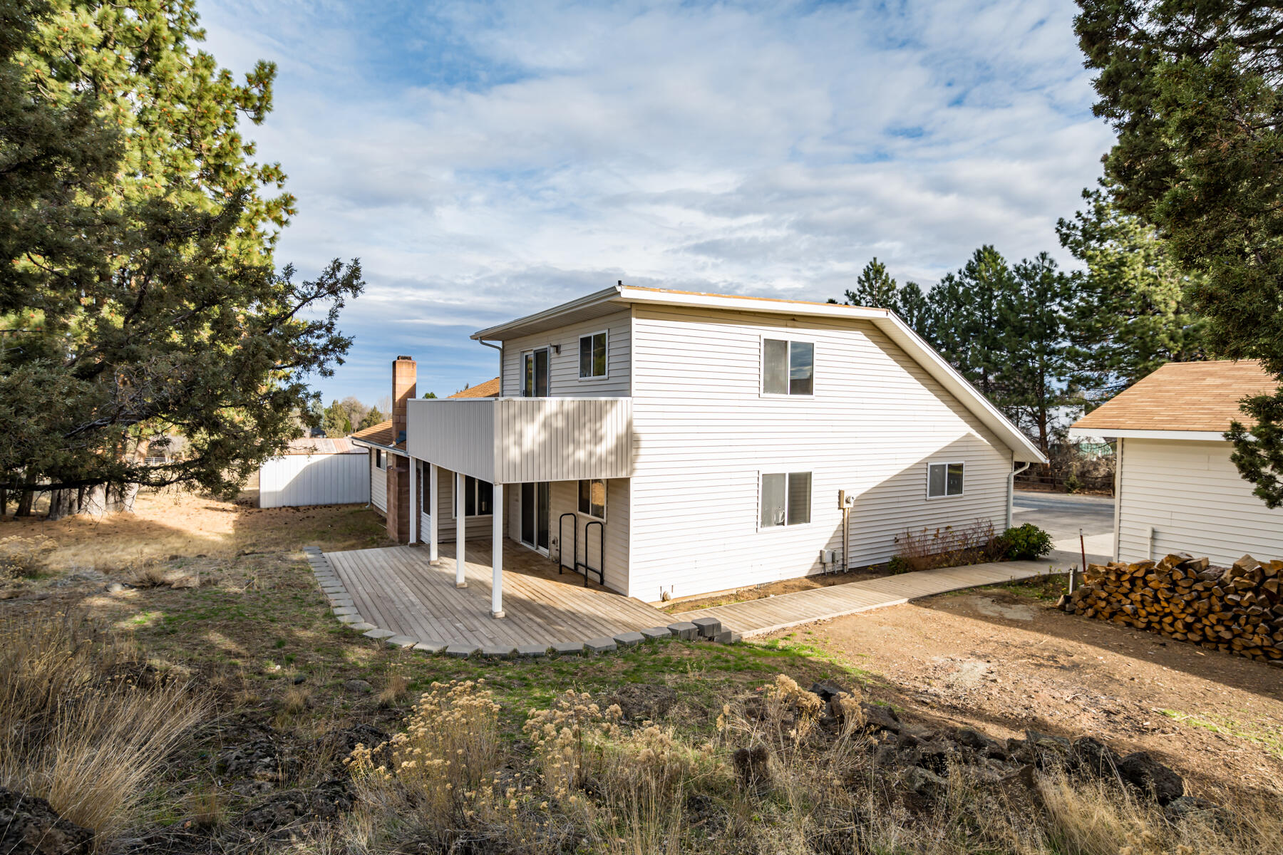 61825 Dobbin Road Bend, OR 97702 - Photo 39 of 43 a view of a white house next to a yard with big trees