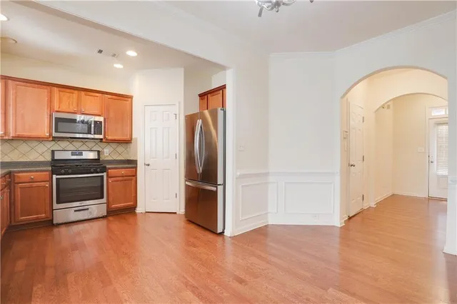 a kitchen with stainless steel appliances a refrigerator and a stove top oven