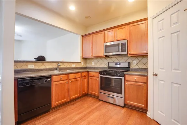 a kitchen with granite countertop stainless steel appliances and wooden cabinets