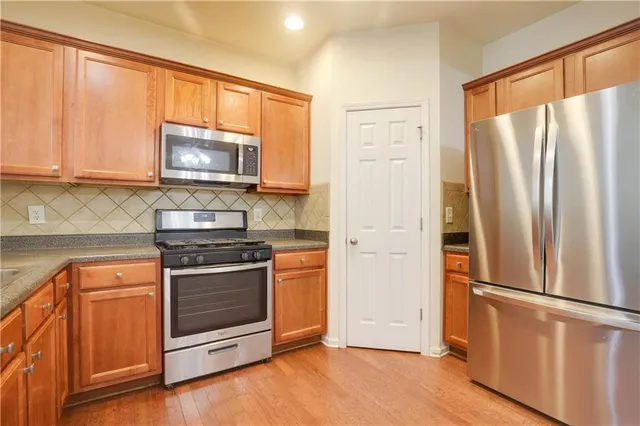 a kitchen with stainless steel appliances a refrigerator stove and microwave
