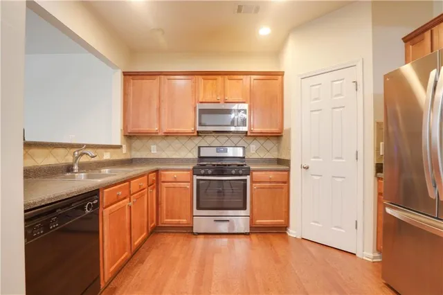 a kitchen with granite countertop a stove top oven and sink