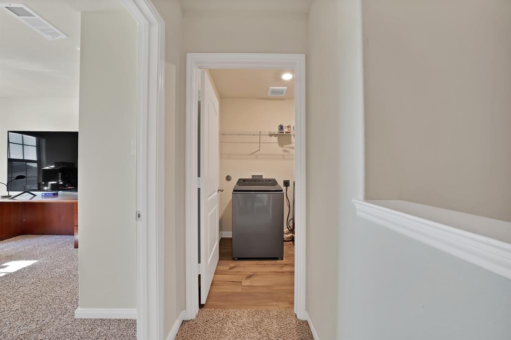 233 Lewis Lane Venus, TX 76084 - Photo 21 of 40 Dedicated upstairs laundry room featuring wood-look flooring, shelving, and full-size washer and dryer connections.