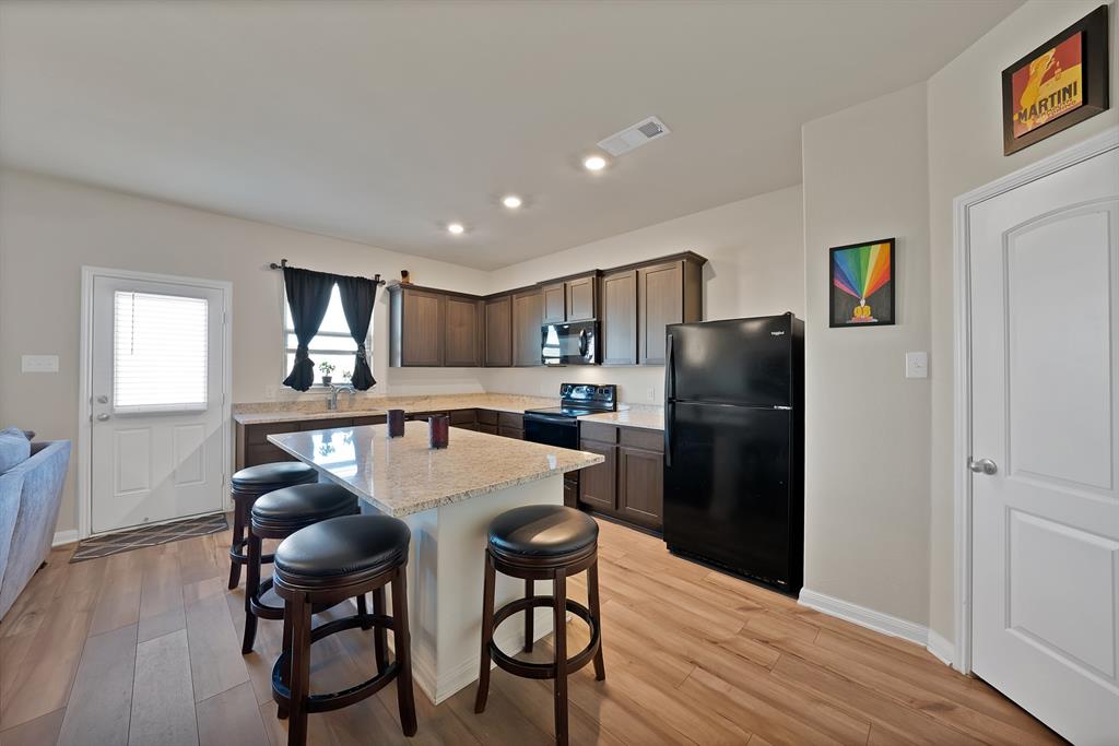 233 Lewis Lane Venus, TX 76084 - Photo 7 of 40 Kitchen view highlighting ample counter space, pantry access, and functional layout perfect for everyday living.