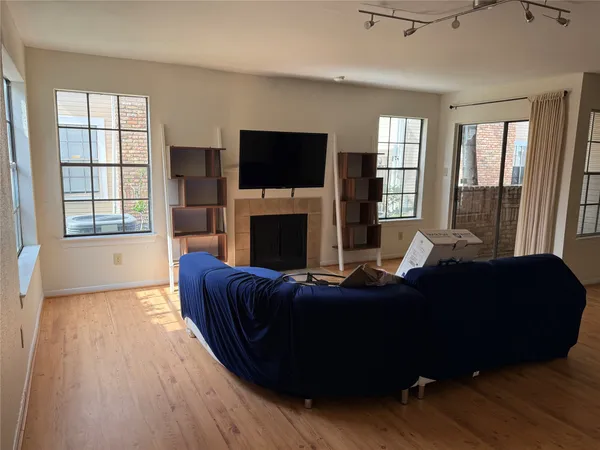 a living room with furniture a flat screen tv and a fireplace
