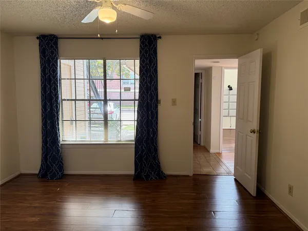 an empty room with wooden floor and mirror