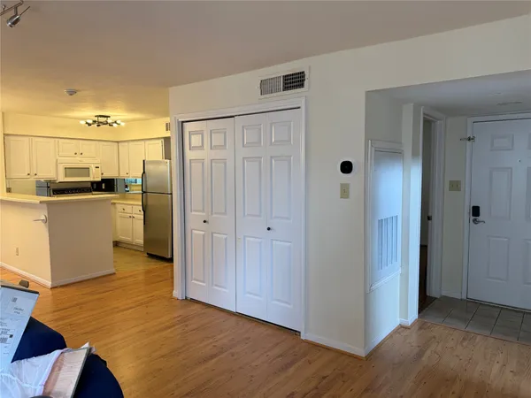 a view of a kitchen with a refrigerator a stove top oven and cabinets