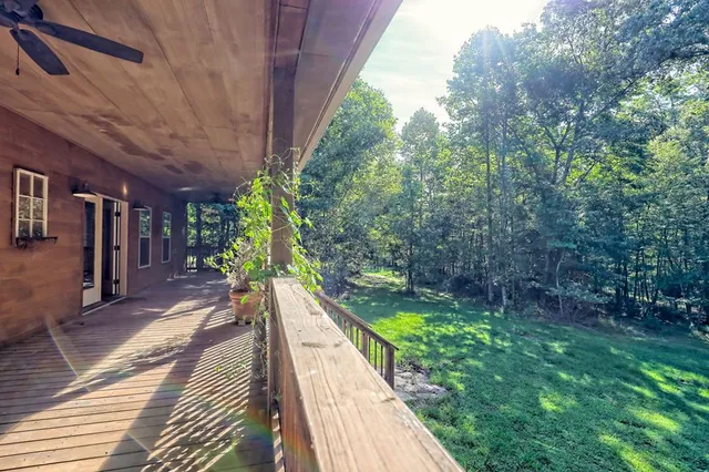 a view of an empty room with wooden floor fireplace and a window