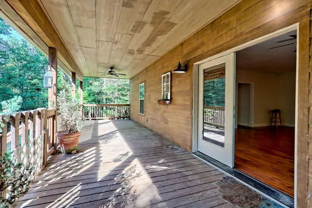 a view of a livingroom with a fireplace a ceiling fan and wooden floor