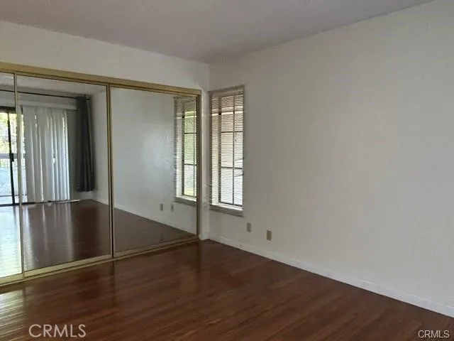 an empty room with wooden floor and door