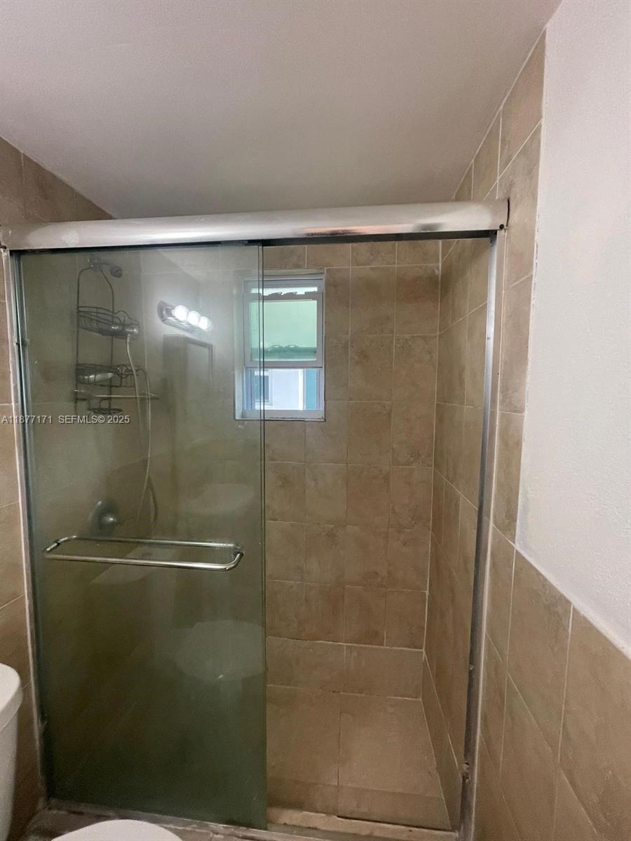 7928 Harding Avenue, Unit 1 Miami Beach, FL 33141 - Photo 16 of 17 a bathroom with a glass door shower