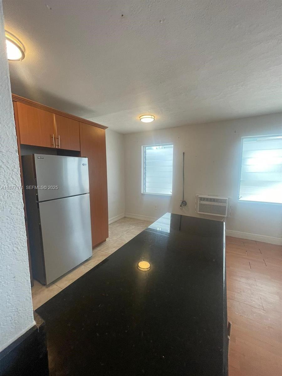 7928 Harding Avenue, Unit 1 Miami Beach, FL 33141 - Photo 6 of 17 a view of an empty room with a window and wooden floor