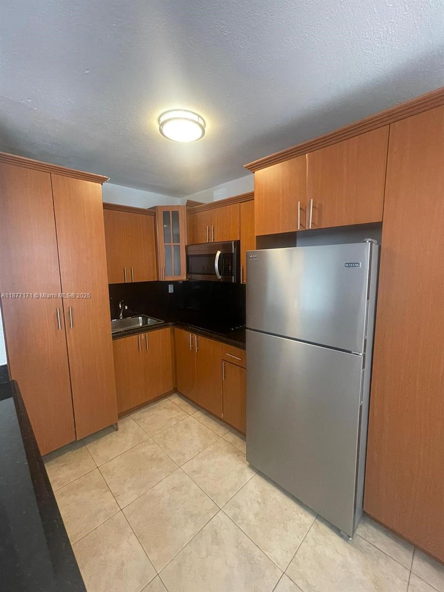 7928 Harding Avenue, Unit 1 Miami Beach, FL 33141 - Photo 8 of 17 a kitchen with a refrigerator and a sink