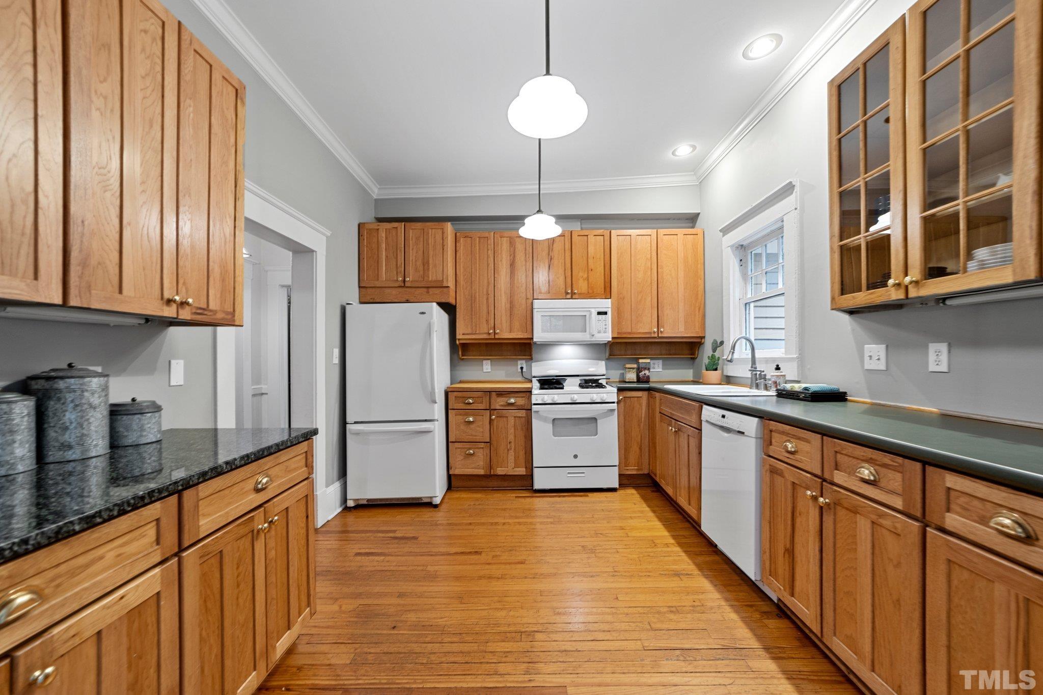 801 Onslow Street Durham, NC 27705 - Photo 12 of 30 a kitchen with stainless steel appliances granite countertop a refrigerator a sink dishwasher a stove and white countertops with wooden floor